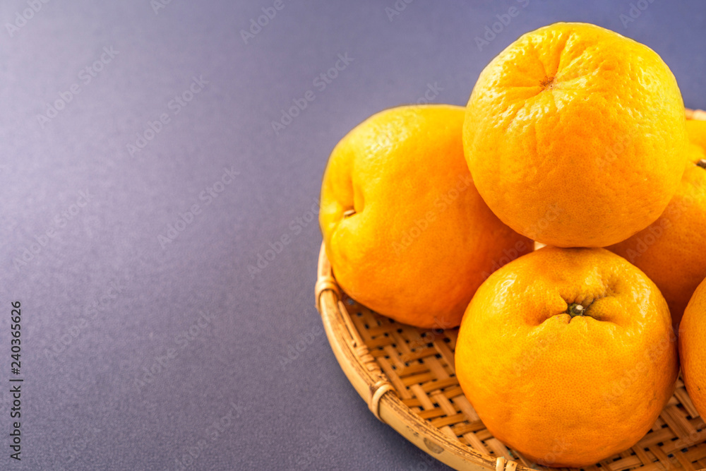 Beautiful and delicous tangerine isolated on airy blue background with bamboo sieve, new modern concept of chinese new year, close up, copy space Beautiful and delicous tangerine isolated on airy blue background with bamboo sieve, new modern concept of chinese new year, close up, copy space