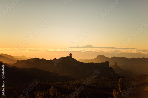 GRAN CANARIA, SPAIN - NOVEMBER 6, 2018: Top view from Roque Nublo mountain under the yellow sky with mist and a Tenerife island © fesenko