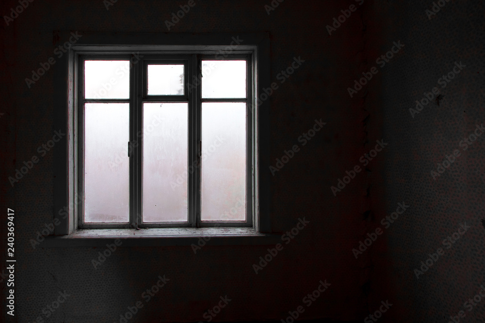 a lighted window in the black room of an abandoned house, a clear outline, glass covered with frost,