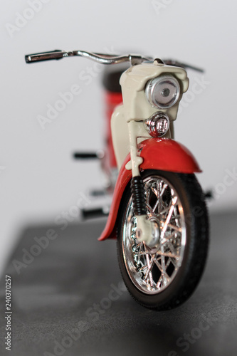 Veteran red plastic motorbike on a stand.