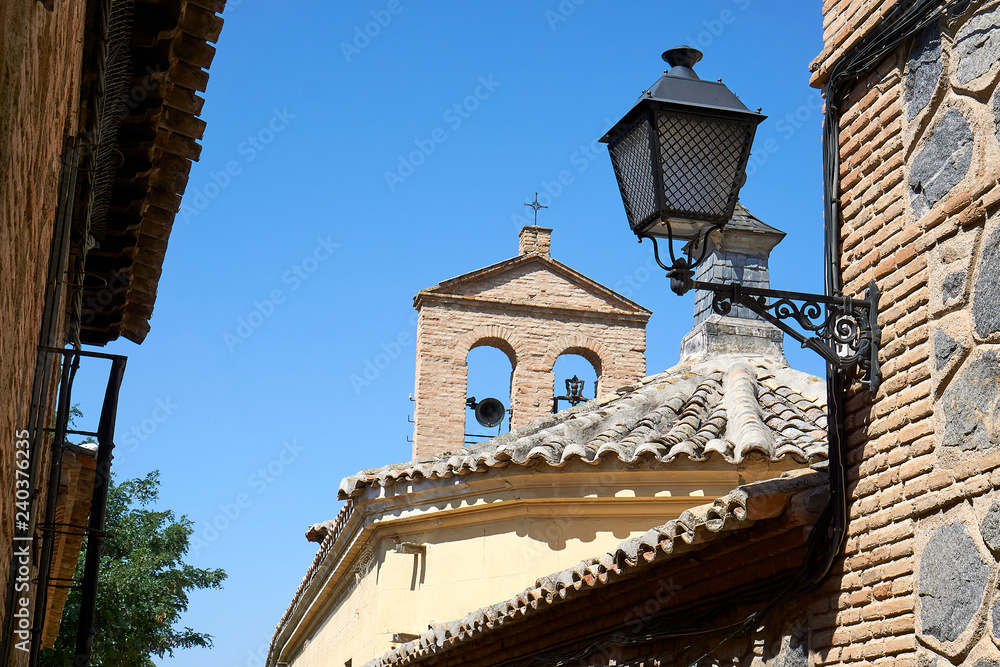 Street lamp and steeple in Toledo on midday