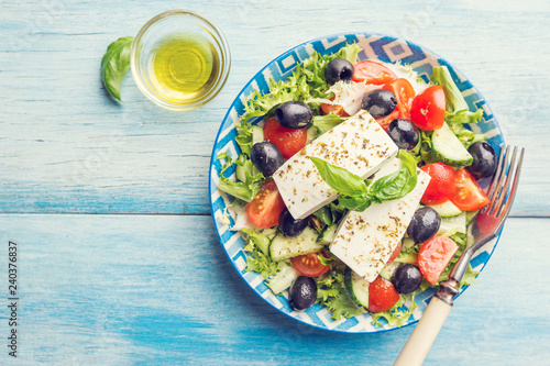 Fresh Greek salad of cucumber, tomato, sweet pepper, red onion, feta cheese and olives with olive oil. Healthy food, top view