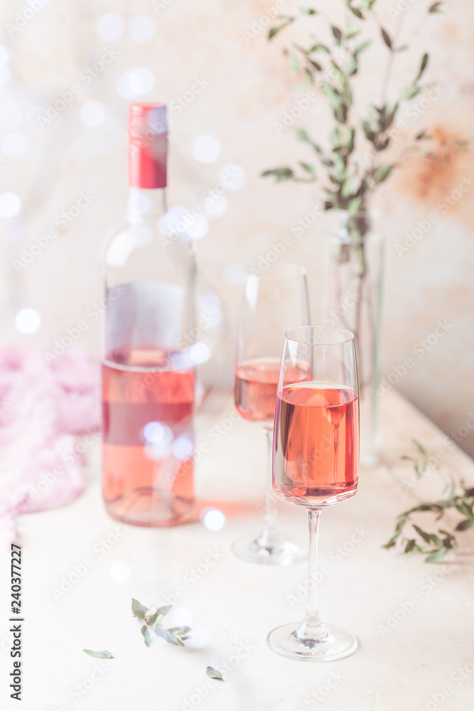 Two glasses and bottle of rose wine on light background. Two glasses and bottle of rose wine on light background.