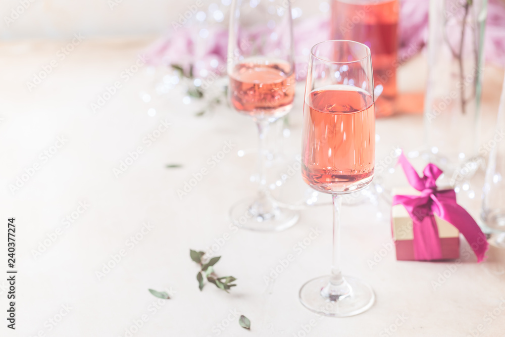 Two glasses and bottle of rose wine on light background. Two glasses and bottle of rose wine on light background.