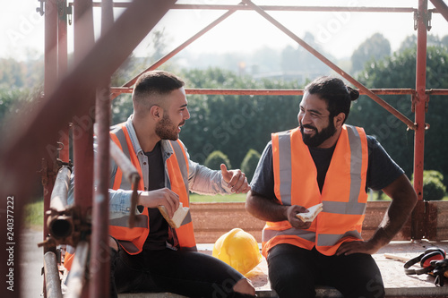 Happy Workers In Construction Site During Lunch Break