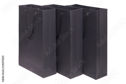 Closeup three black paper empty packages with handles isolated on white background. Concept retail, shopping, stylish laconic packaging of underwear, alcohol, christmas gifts