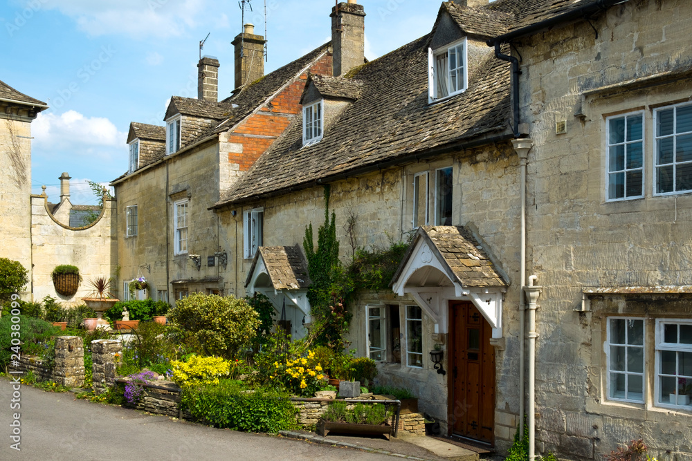 Many picturesque old Cotswold stone houses line the streets in Painswick, Gloucestershire, UK