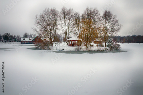 The winter landscape with forest, lake in the bad weather condition
