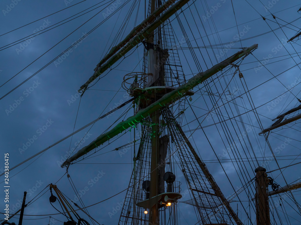 Masts and the rigging of ancient sailboat on nignt sky background. Exterior of old tall ship. Amerigo Vespucci - bow of ancient sailing vessel. Masts and the rigging of ancient sailboat on nignt sky background. Exterior of old tall ship. Amerigo Vespucci - bow of ancient sailing vessel.