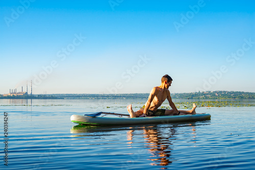 Man practicing yoga on a SUP board