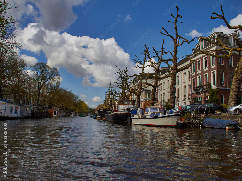 Fototapeta premium Amsterdam photos jn canal with white clouds