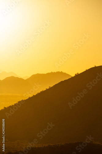 The sun rising over the mountains of the Arizona desert with natural warm hues.