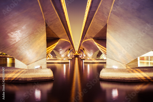 Photography Two bridges at night spanning a body of water with symmetric architecture