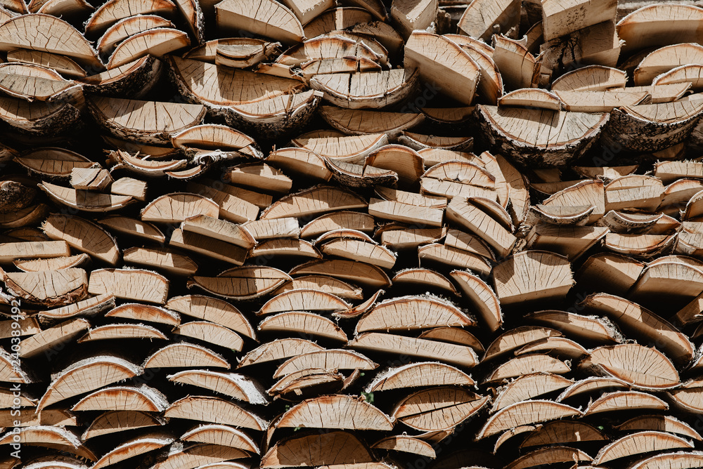 A stack of birch firewood - a natural vertical background