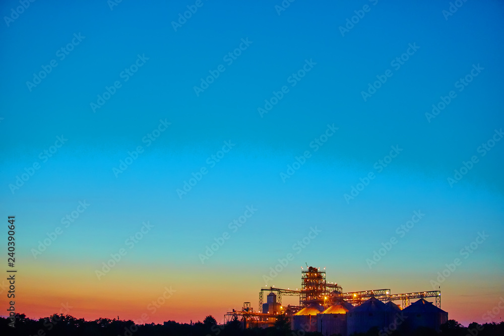 Obraz premium Agricultural Silo - Building Exterior, Storage and drying of grains, wheat, corn, soy, sunflower against sunset. 