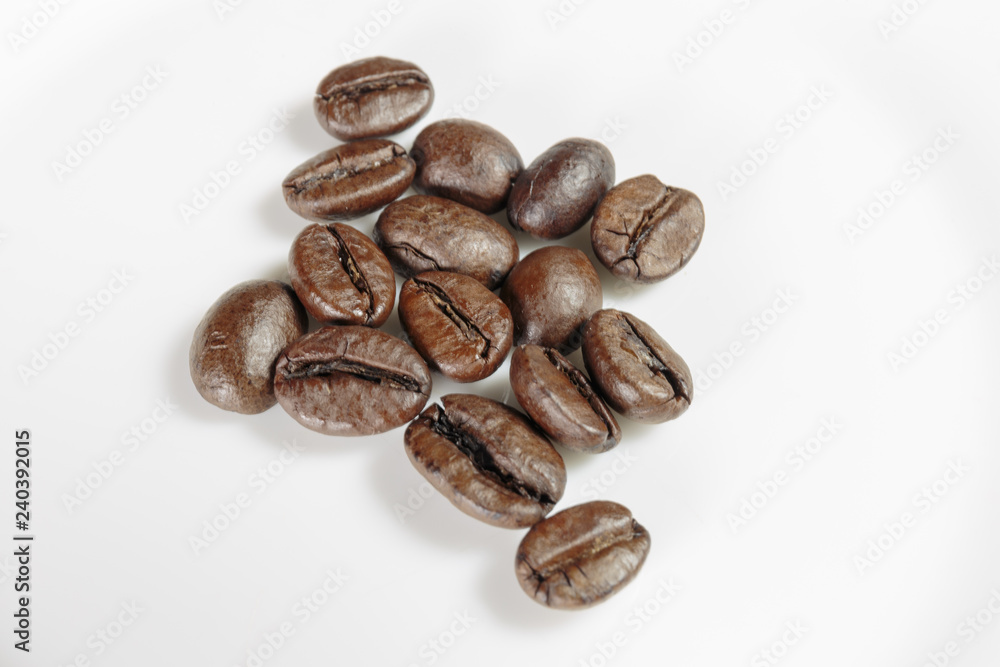 Fototapeta premium Well-stocked coffee beans on a white background close-up.