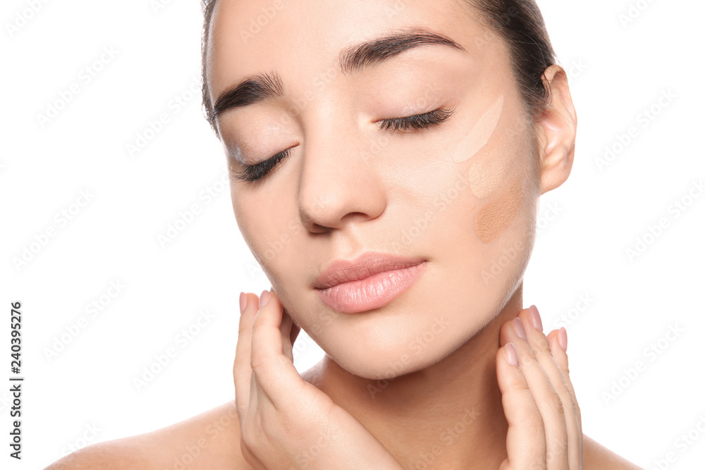Young woman with different shades of skin foundation on her face against white background Young woman with different shades of skin foundation on her face against white background