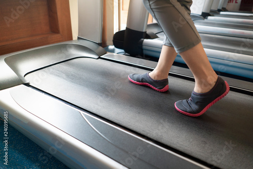 Female legs walking and running on treadmill in gym.  Exercising cardio workout © marchsirawit