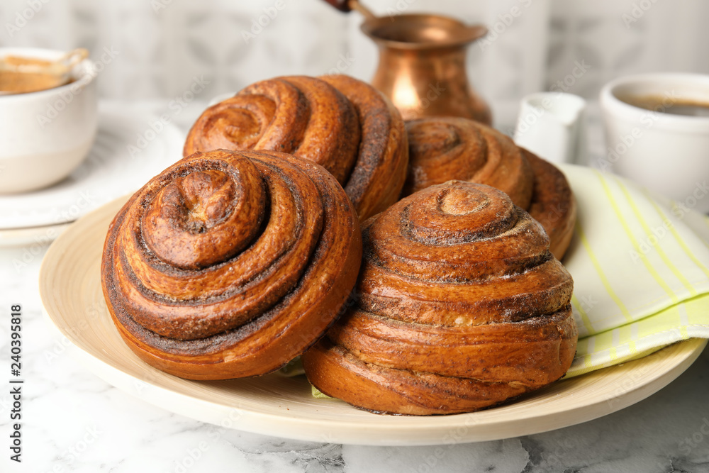 Fototapeta premium Plate with baked cinnamon rolls on table