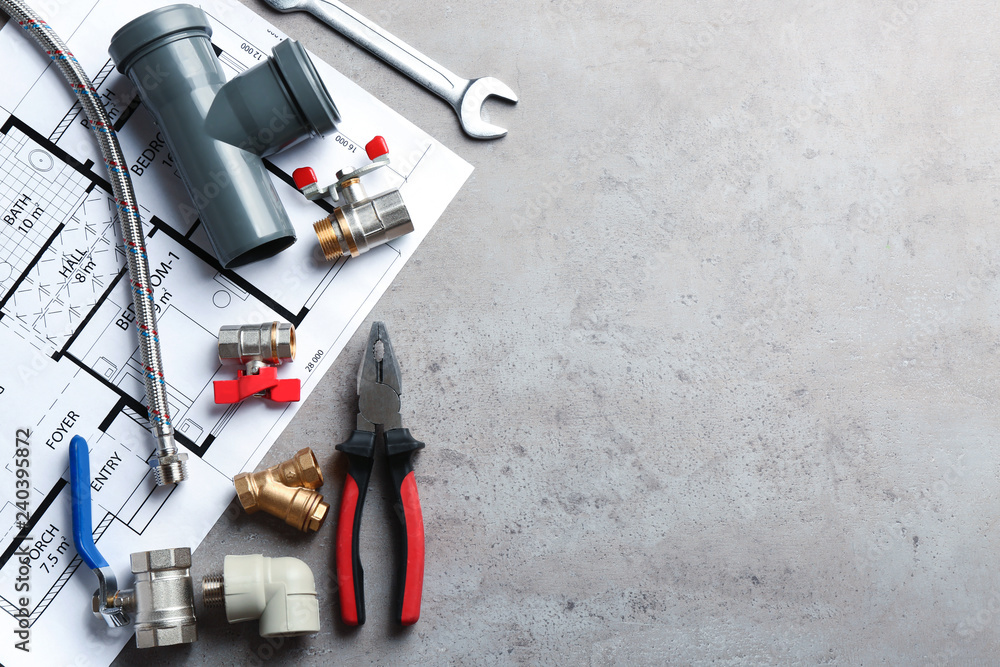 Fototapeta premium Flat lay composition with plumber's tools and space for text on grey background