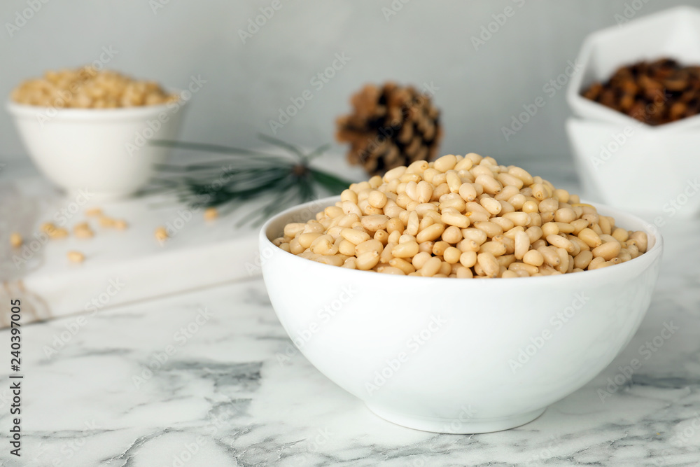 Bowl with pine nuts on marble table. Space for text Bowl with pine nuts on marble table. Space for text
