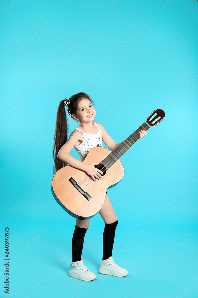 Cute little girl playing guitar on color background Cute little girl playing guitar on color background