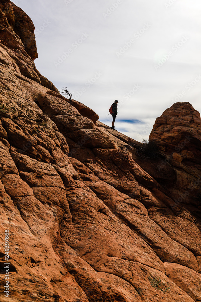woman silhouette hiking sandstone in Utah