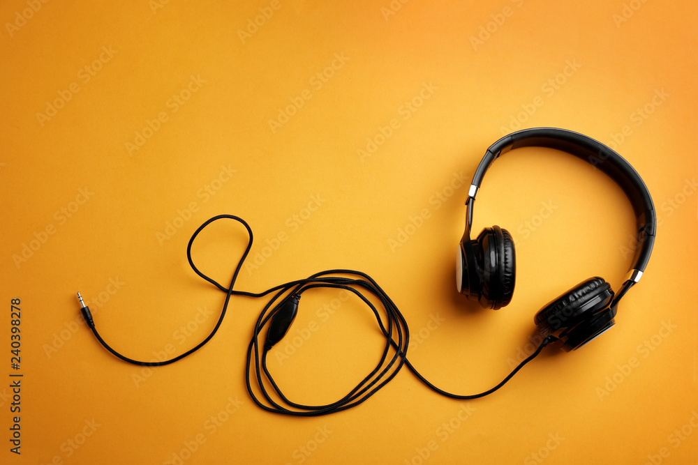 Stylish headphones on color background, top view. Space for text Stylish headphones on color background, top view. Space for text