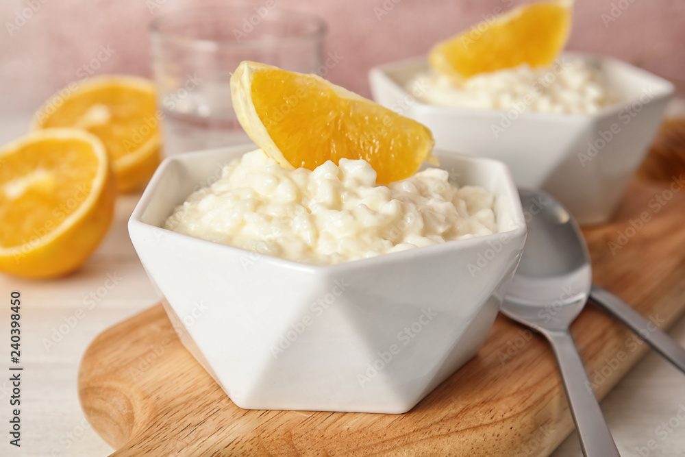 Creamy rice pudding with orange served on wooden table Creamy rice pudding with orange served on wooden table