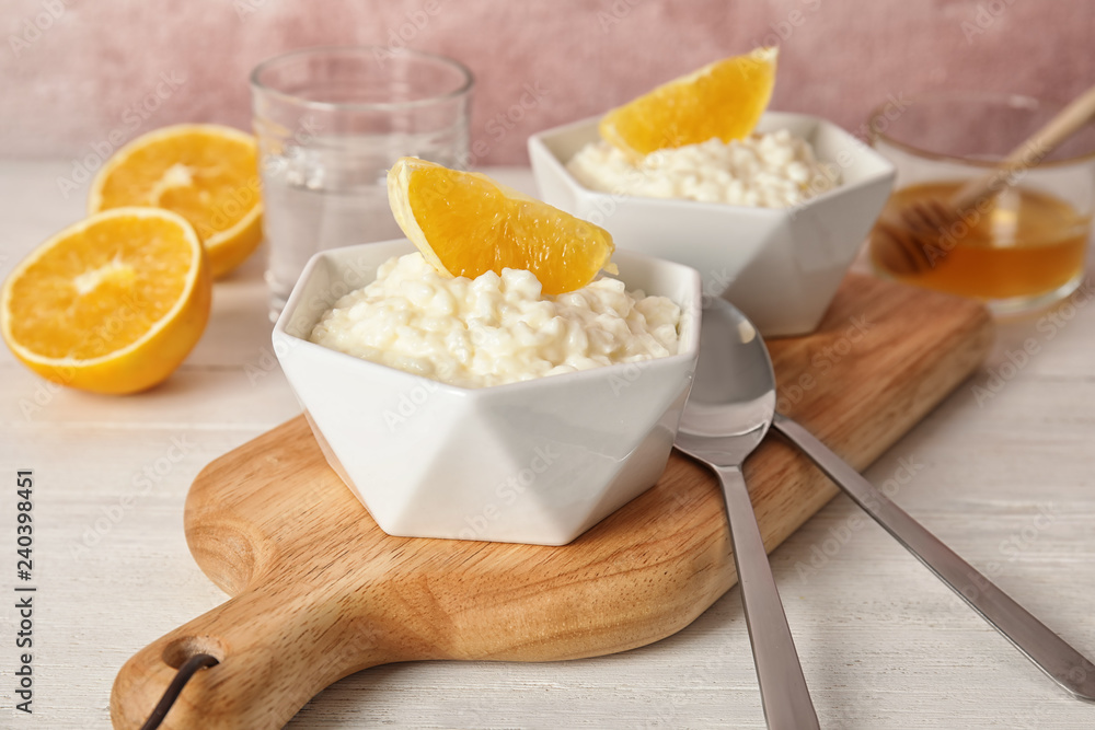 Creamy rice pudding with orange served on wooden table Creamy rice pudding with orange served on wooden table