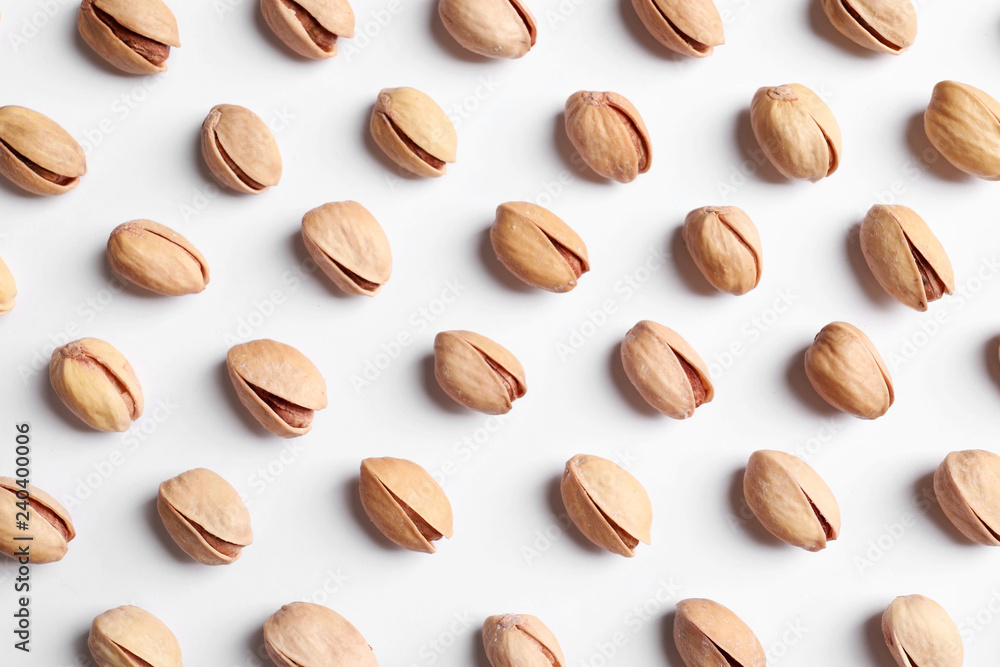 Organic pistachio nuts on white background, flat lay