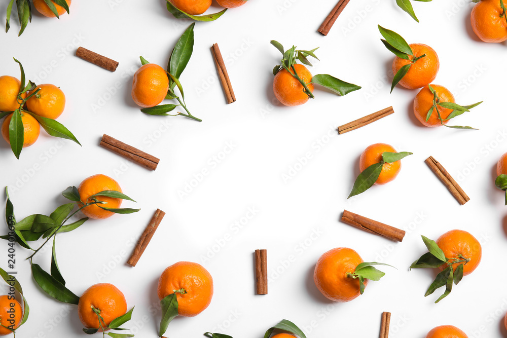 Christmas composition of cinnamon and ripe tangerines with space for text on white background, flat lay Christmas composition of cinnamon and ripe tangerines with space for text on white background, flat lay