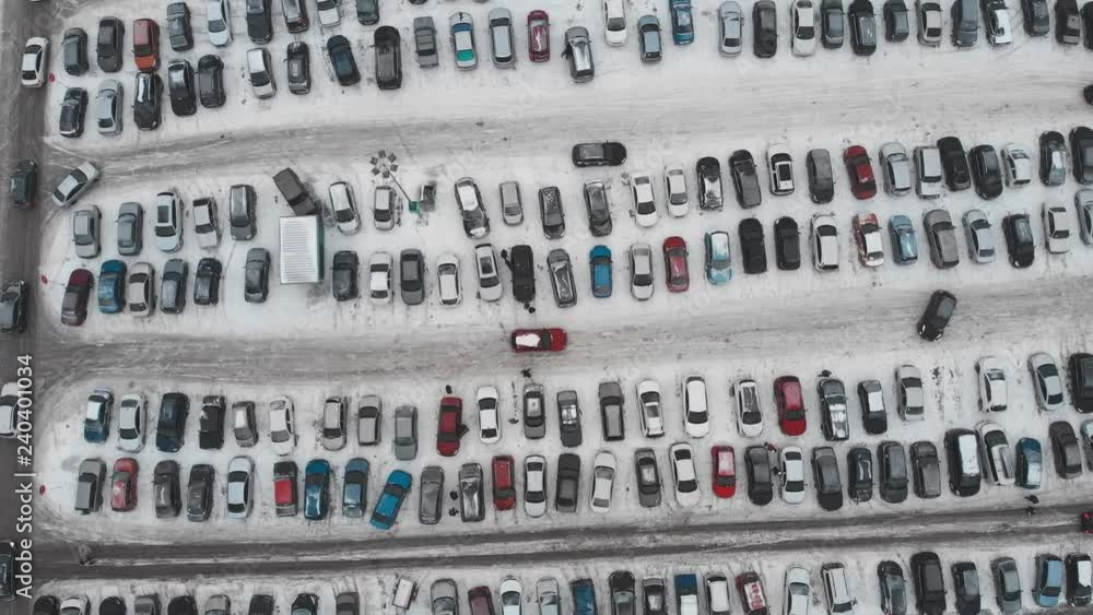 Aerial view from drone of large automobile parking lot with many cars near mall or shopping center in winter with snow, urban transportation Aerial view from drone of large automobile parking lot with many cars near mall or shopping center in winter with snow, urban transportation