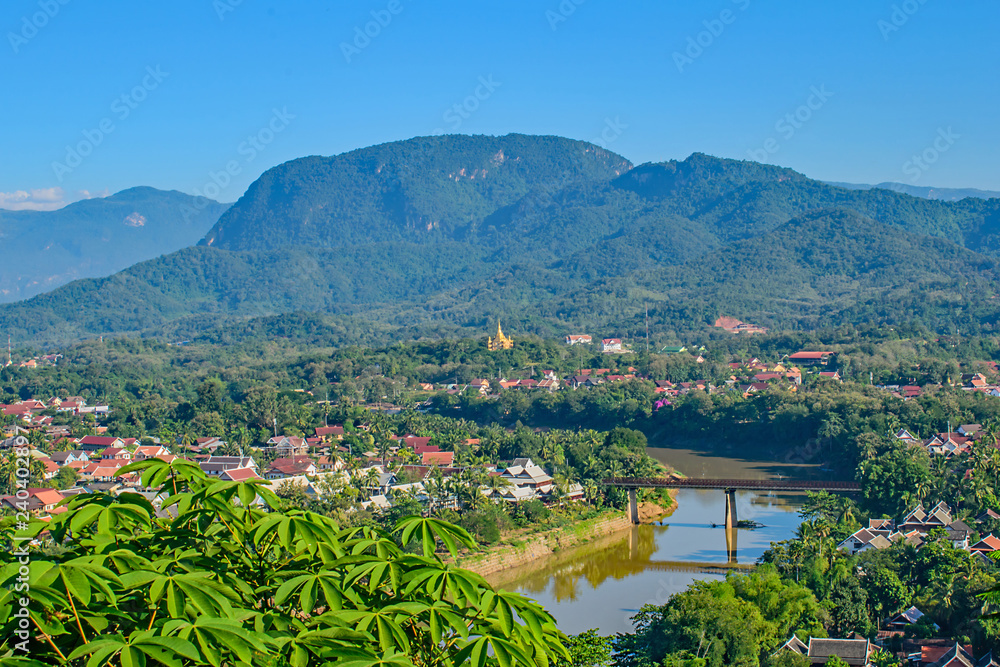 A high view from Phou Si Hill Laos across the bridge to the colourful roofs and hills beyond