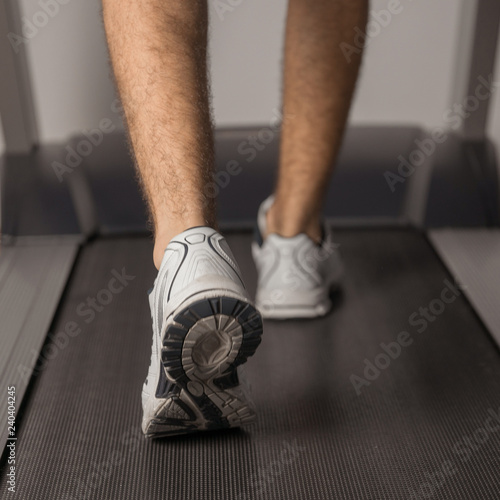The legs of man running on treadmill in the gym. Health and sport concept. Healthy lifestyles