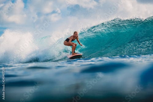 Surf girl on surfboard. Surfer woman and blue wave