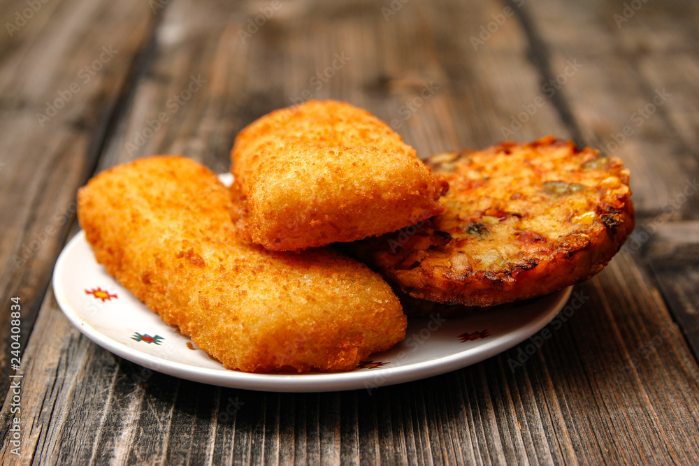 Crispy breaded fried fish fillet and vegetarian burger made from various type of vegetables on old wooden table Crispy breaded fried fish fillet and vegetarian burger made from various type of vegetables on old wooden table