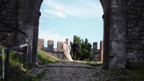 Bride and groom walking into the old castle.