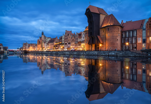 Gdansk, Poland. Embankment of canal in Old Town with famous historic port crane reflecting in water at dusk