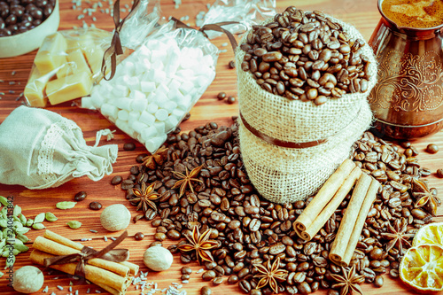 coffee beans and spices on an old wooden background, anise, cinnamon and nutmeg © Olya