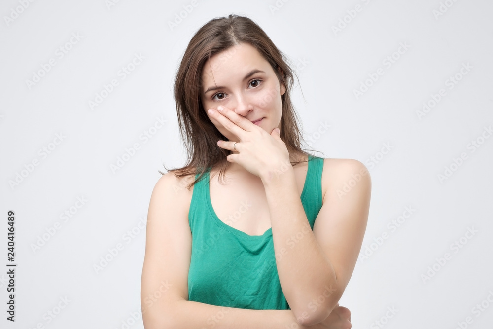 Young charming girl in green t-shirt on the white background. Facial human emotion Young charming girl in green t-shirt on the white background. Facial human emotion