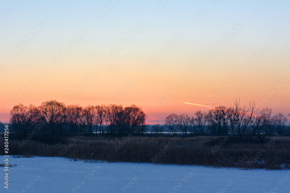 Sunset in the winter over the river covered with ice Sunset in the winter over the river covered with ice