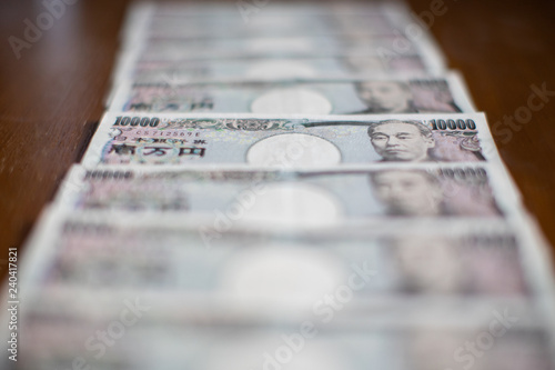 Front side of ten thousand yen japanese money (JPY) on brown table background