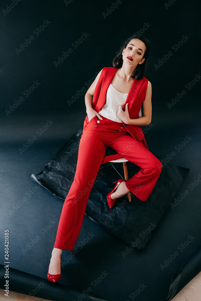 Portrait of beautiful brunette girl with makeup in fashion red clothes