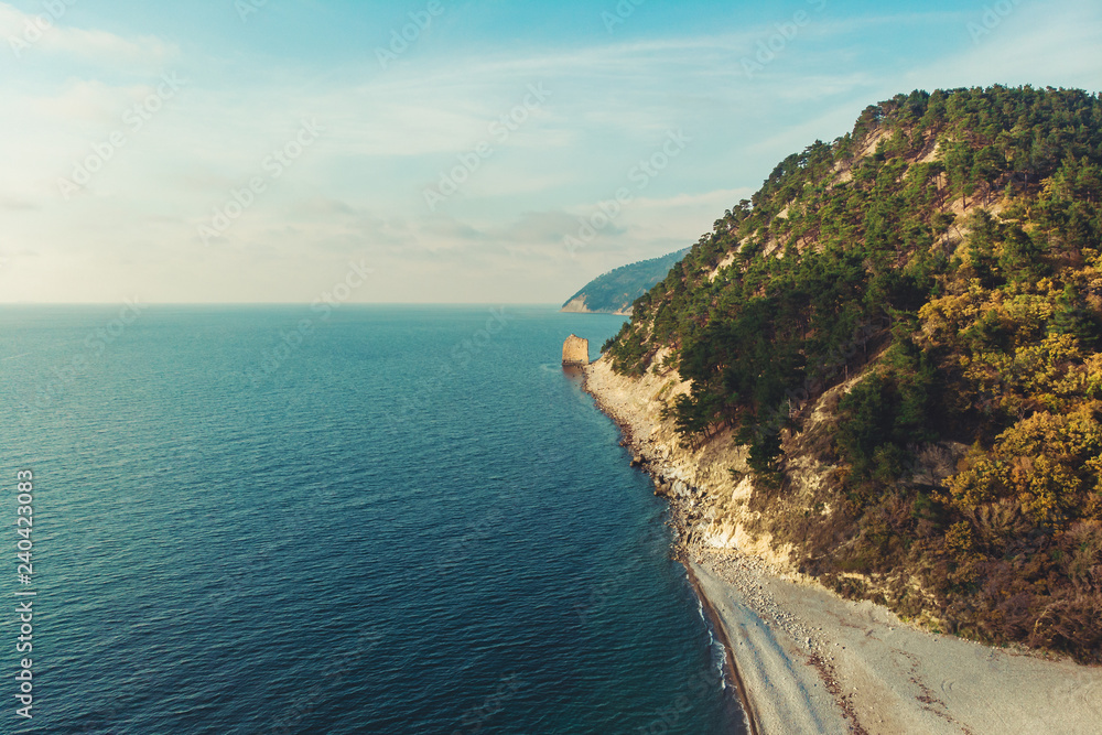 Black sea coast with mountain in forest and beach, blue ocean water and coastline as beautiful tropical paradise background, aerial view from drone