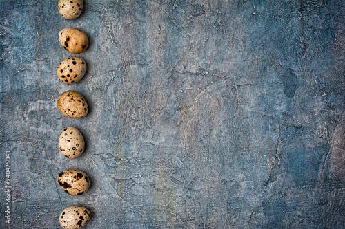 Top view on small quail eggs on blue concrete