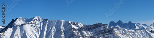 Panorama of snowy mountains and blue clear sky