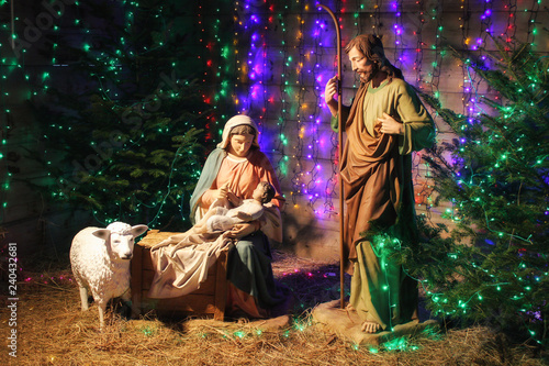 Christmas Manger scene with figures including Jesus, Mary, Joseph, sheep and magi. Soft focus