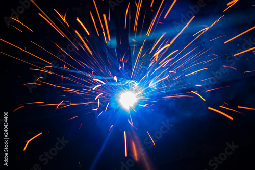 Spark of the electric welding with the sparks of burning hot metal..