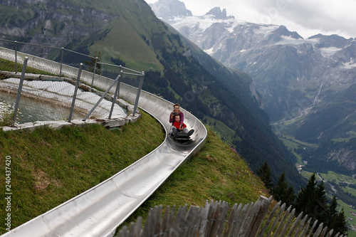 Mother and son sliding down an alpine coaster on vacation laughing. photo